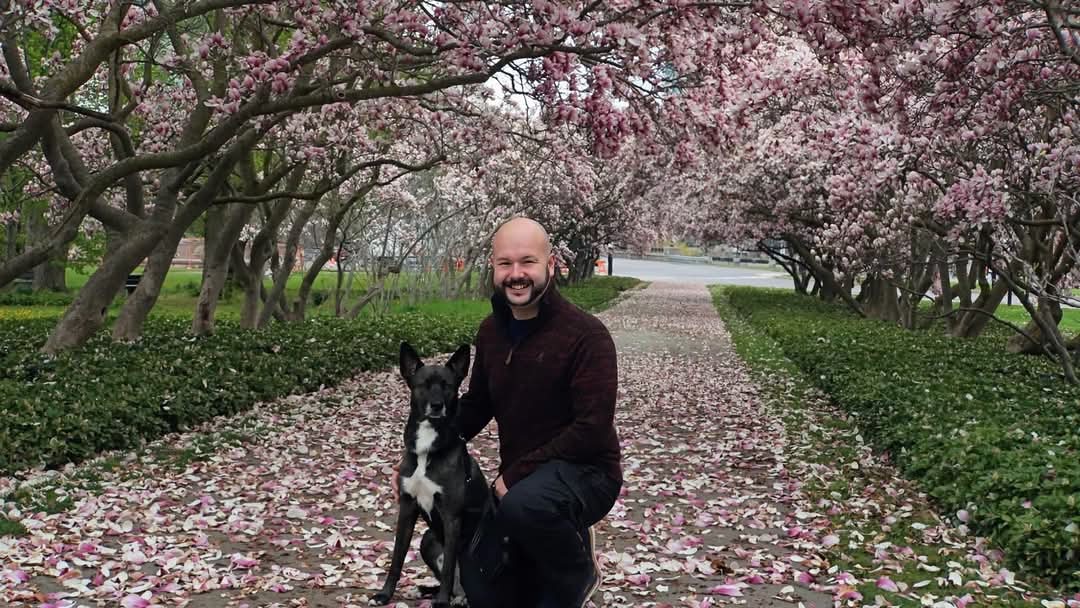 Matthew with Poe beneath flowering trees